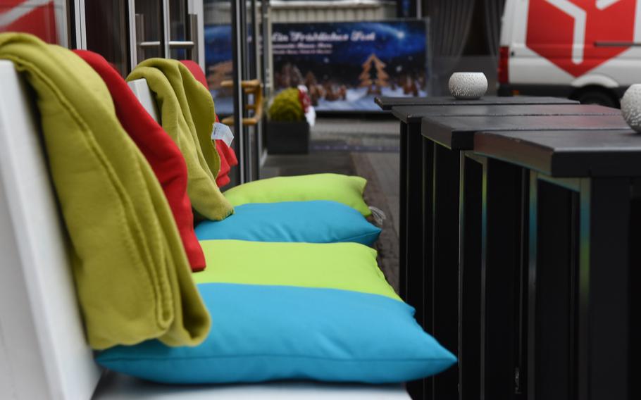 Cozy outdoor seating with pillows and blankets at Le Petit Frederic, a new bistro in Kaiserslautern, Germany, is a good place to sit with a warm drink or glass of wine and people watch.