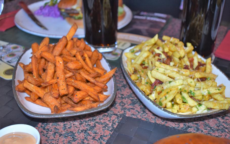 Burger Zone in Kaiserslautern, Germany, supplements its diverse menu of burgers with several different options for fries. At left is an extra-large plate of sweet potato fries, joined by an extra-large plate of dirty fries topped with cheese and bacon.