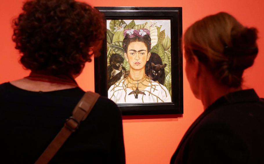 Two visitors to the exhibit "Fantastic Women" look at Frieda Kahlo's "Self-Portrait with Thorn Necklace and Hummingbird," probably the exhibit's most famous piece. The program runs through July 5 at the Schirn exhibit hall in Frankfurt, Germany.