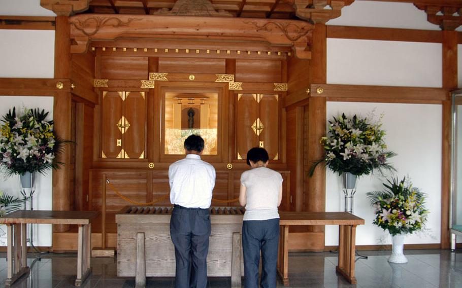 Here, at Tokko Kannon Do (also called the Kamikaze Temple), two Japanese visitors pray before the 1.8 foot-tall statue of the Tokko Kannon Zo, or Goddess of Mercy, for the pilots who perished at the end of the war. The names of each of the 1,036 army kamikaze pilots are written on a piece of paper contained inside her womb.
