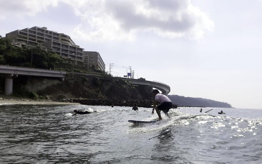 A surfer rides a wave at Yugawara Beach in Kanagawa prefecture, Japan. 