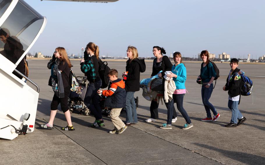 U.S. military family members board a flight from Yokota Air Base, Japan, to Seattle on March 19. They were taking part in a voluntary evacuation after a March 11 earthquake and tsunami resulted in a possible nuclear crisis in Japan. 