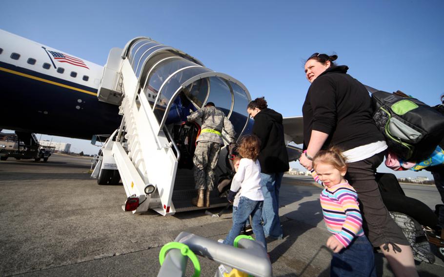 U.S. military family members board a flight Saturday from Yokota Air Base, Japan, to Seattle.

