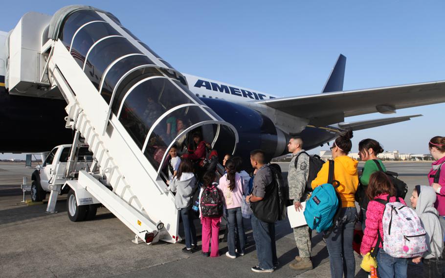 U.S. military family members board a flight from Yokota Air Base to Seattle, Saturday.
