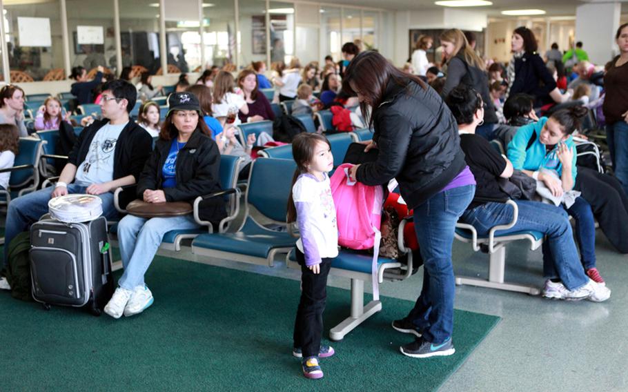 U.S. military family members wait to board a flight from Yokota Air Base, Japan, to Seattle, on Saturday. They were taking part in a voluntary evacuation as concerns grow over a nuclear disaster in the wake of a devastating earthquake and tsunami in Japan.