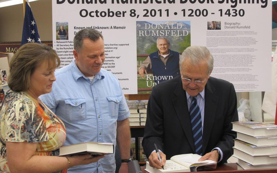 Former Secretary of Defense Donald Rumsfeld signs eight copies of his book, "Known and Unknown," for Denise Stonum and Cmdr. Tom Stonum at Yokosuka Naval Base on Saturday. The Stonums say they plan to give copies of the book to friends and family. Rumsfeld, one of the most polarizing of America's political leaders in recent years, met nothing but adoring fans at Yokosuka.