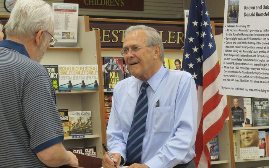 Former Secretary of Defense Donald Rumsfeld signs a copy of his book, "Known and Unknown," at Yokosuka Naval Base in 2011. Rumsfeld, one of the most polarizing of America's political leaders in recent years, met nothing but adoring fans at Yokosuka.