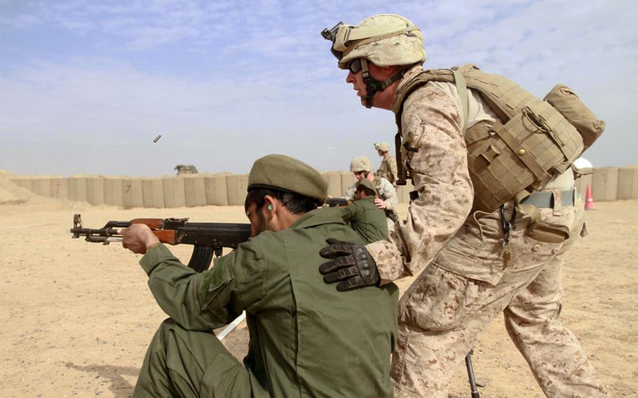 Cpl. Michael Russman, an infantryman attached to Headquarters and Service Company, 1st Battalion, 9th Marine Regiment, coaches an Afghan at a small arms firing range in November 2011. An Afghan soldier shot and killed four NATO troops in eastern Afghanistan on Friday.