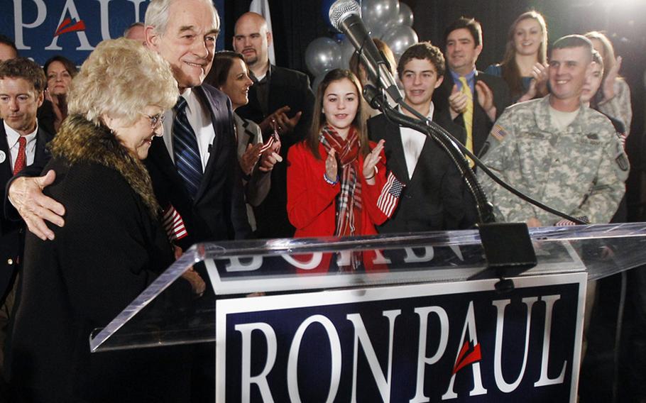 Republican presidential candidate Rep. Ron Paul, R-Texas, attends his caucus night rally with wife, Carol, family and friends on Jan. 3, 2012, in Ankeny, Iowa. At right is Cpl. Jesse Thorsen, an Iowa-based Army reservist. Thorsen will receive only a letter of reprimand for violating military politicking rules.