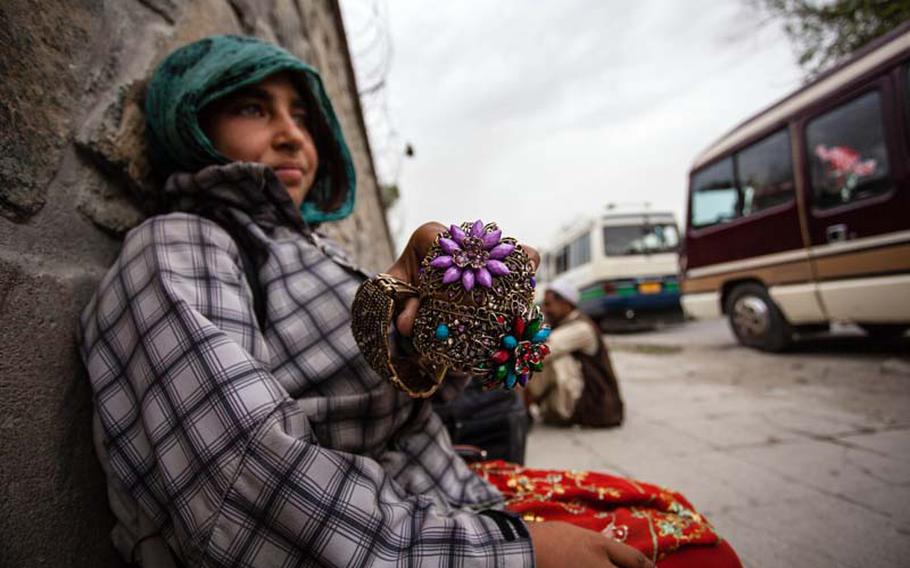 Farzana, 10, shows off some metal bracelets she plans to sell to American and coalition troops.
