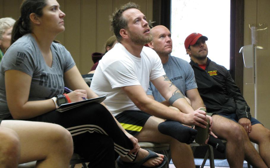 Maj. Dana Riegel (left), Army veteran Jim Buzzell (second from left) and other participants at Team Red, White & Blue's November running camp get tips on preventing common knee and back injuries.