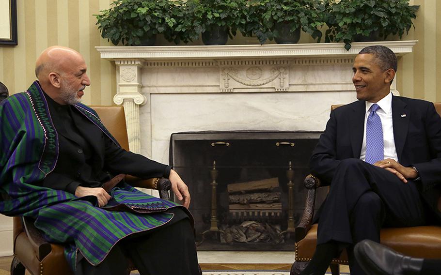 President Barack Obama and Afghan President Hamid Karzai talk during a meeting at the White House in Washington, on Friday, Jan. 11, 2013.