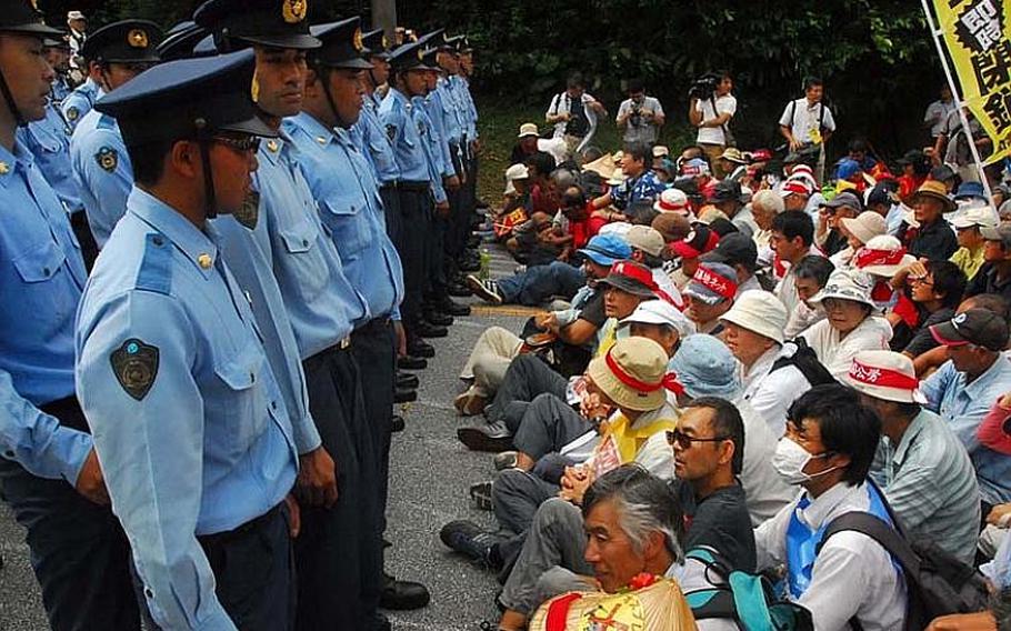 Japanese police stand guard over demonstrators who blocked the main gate of the Futenma air station Sept. 28, 2012, to protest the planned deployment of the controversial Osprey aircraft to Okinawa. U.S. Air Force talk of deploying the tilt-rotor aircraft to Japan is sparking fears more may be headed to Okinawa.