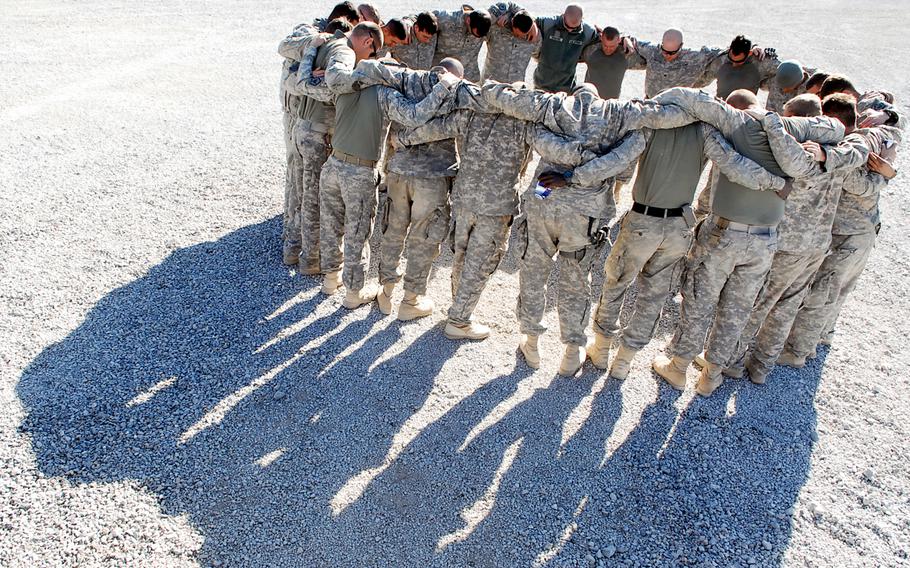 Soldiers with 4th Engineer Battalion, 62nd Engineer Sapper Company, 3rd Platoon pray before a mission conducted the day after their convoy was hit by three roadside bombs. 