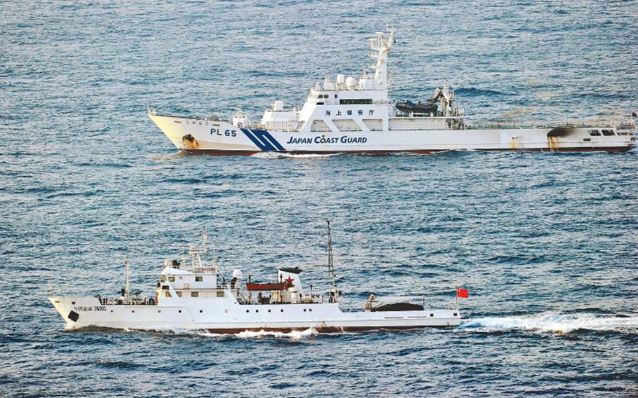 A Chinese fishery monitoring ship, foreground, is trailed by a Japan Coast Guard patrol vessel in the contiguous zone about 38 kilometers north of Uotsurijima island Tuesday, Sept. 18, 2012.