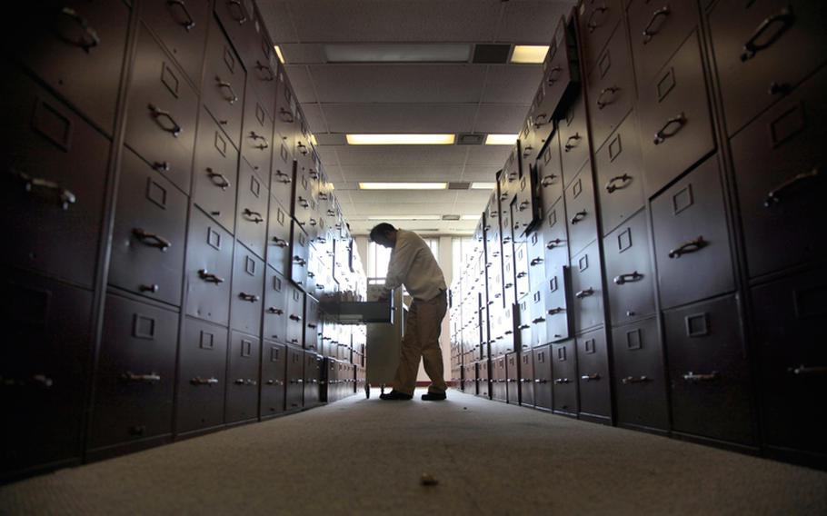 A claims assistant files veterans cases into enormous rows of filing cabinets at the U.S. Department of Veterans Affairs in Los Angeles on December 5, 2012.