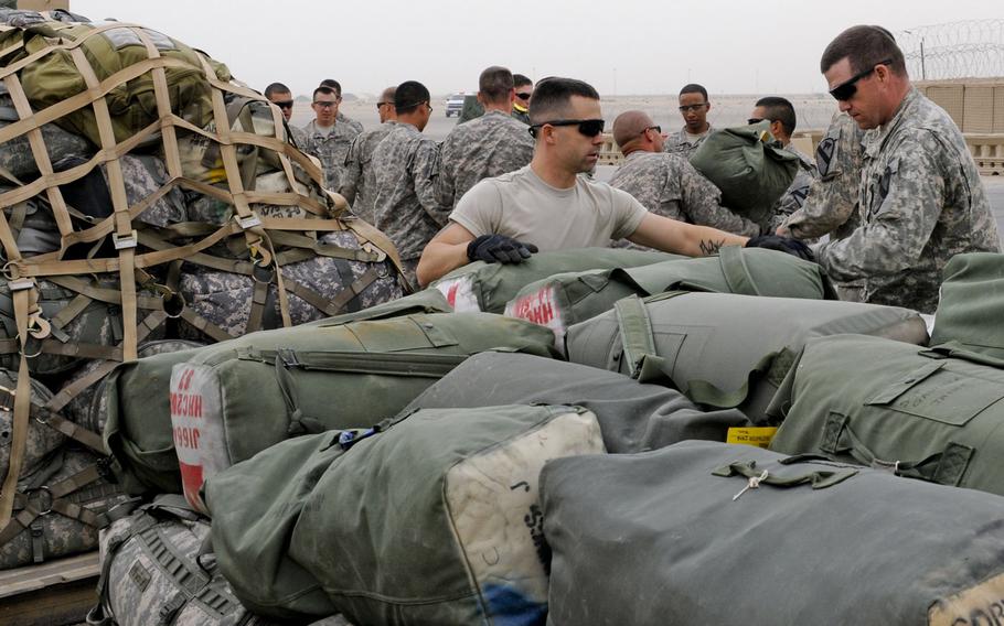 Soldiers with the 3rd Brigade Combat Team, 8th Cavalry Regiment, load their equipment onto pallets on Contingency Operating Base Adder Oct. 26, 2011.. The C-130 aircraft carried soldiers and their palletized equipment out of Iraq.