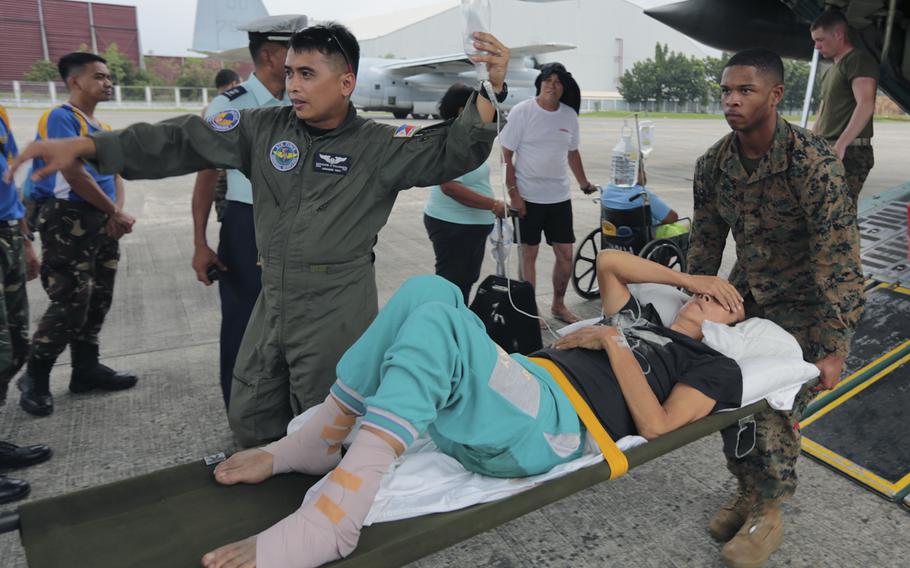 U.S. Marines carry an injured Filipino woman on a stretcher for medical attention, assisted by a Philippine Air Force airman at Vilamore Air Base, Manila, Republic of the Philippines Nov. 11, 2013. Super Typhoon Haiyan has impacted more than 4.2 million people across 36 provinces in the Philippines, according to the Philippine government's national disaster risk reduction and management council.