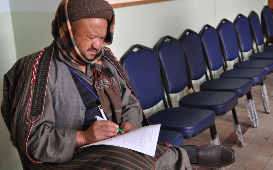 A member of the Afghan Loya Jirga reads through a proposed security agreement with the United States that would pave the way for international troops to stay in Afghanistan past the end of 2014. The jirga, a gathering of 2,500 community leaders from around the country, was convened by President Hamid Karzai who has said he will respect the council's decision on the security agreement.