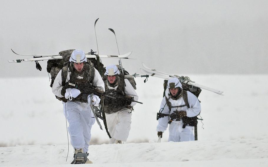 Paratroopers assigned to the 1st Squadron (Airborne), 40th Cavalry Regiment, move off the drop zone after an Arctic airborne operation in the complete over-white uniform on Malemute Drop Zone at Joint Base Elmendorf-Richardson, Alaska, Dec. 12, 2013.