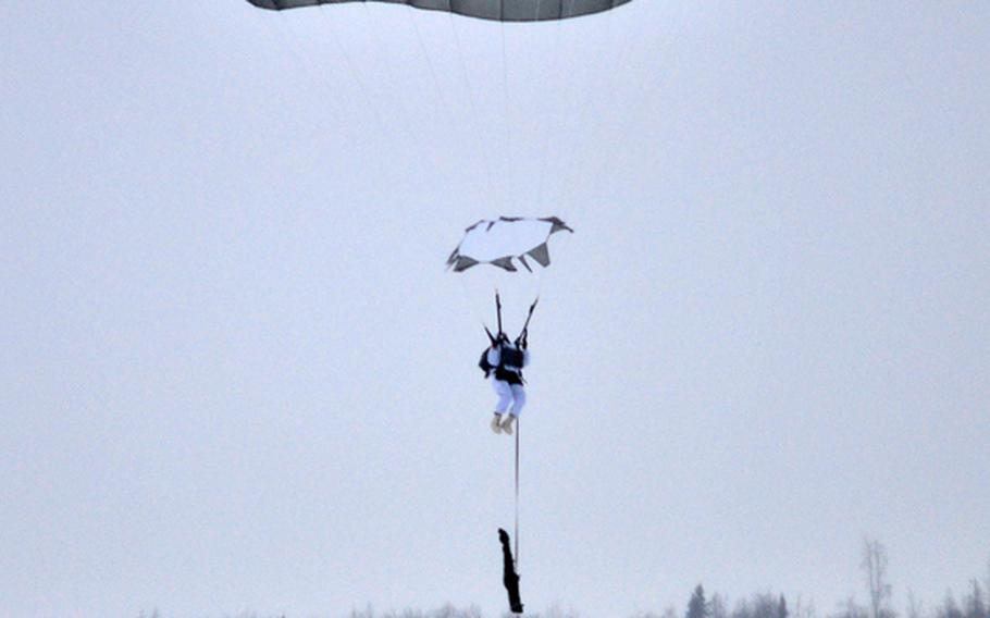 A paratrooper assigned to the 1st Squadron (Airborne), 40th Cavalry Regiment prepares for his parachute landing fall during an Arctic airborne operation in the over-white uniform on Malemute Drop Zone at Joint Base Elmendorf-Richardson, Alaska, Dec. 12, 2013. The unit is part of U.S. Army Alaska's 4th Infantry Brigade Combat Team (Airborne), 25th Infantry Division. This is the first Arctic airborne operation for the brigade since its redeployment from Afghanistan last year.