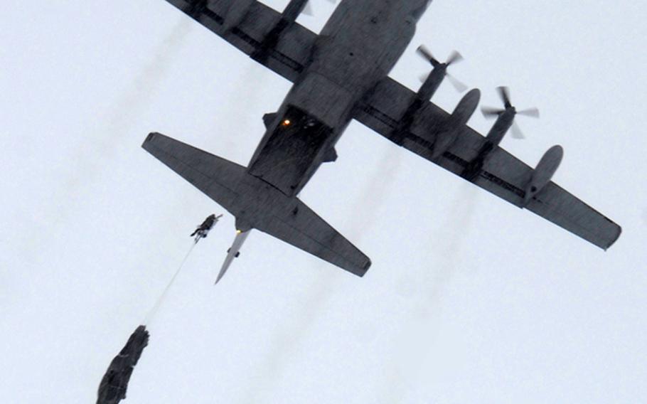 A paratrooper assigned the 1st Squadron (Airborne), 40th Cavalry Regiment, 4th Infantry Brigade Combat Team (Airborne), 25th Infantry Division, part of U.S. Army Alaska, is seen jumping from a C-130 Hercules aircraft during an Arctic airborne operation in the complete over-white uniform on Malemute drop zone at Joint Base Elmendorf-Richardson, Alaska, Dec. 12, 2013.