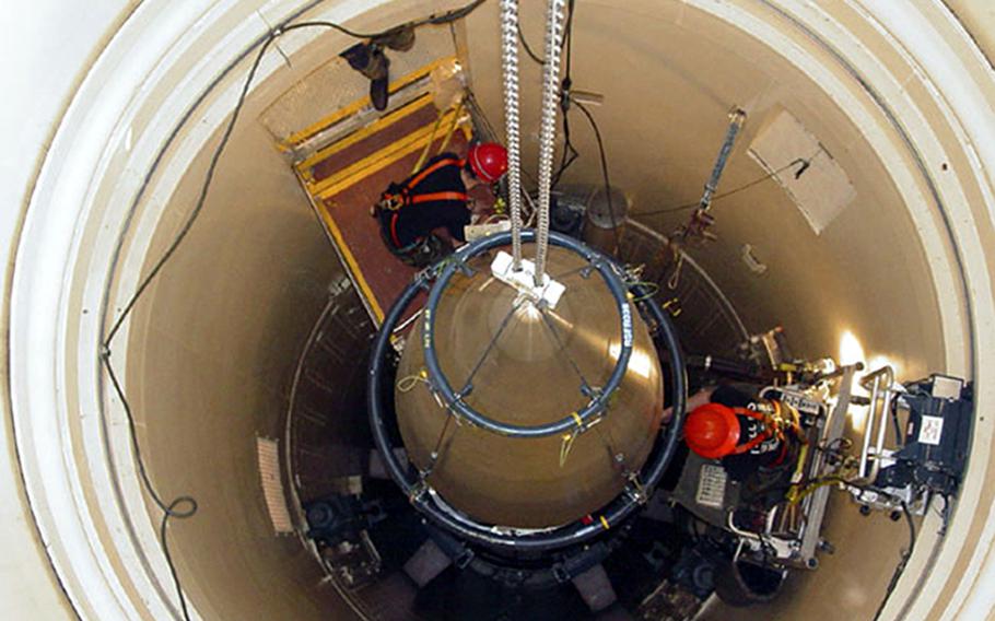 In this image released by the U.S. Air Force, a Malmstrom Air Force Base missile maintenance team removes the upper section of an ICBM at a Montana missile site. 