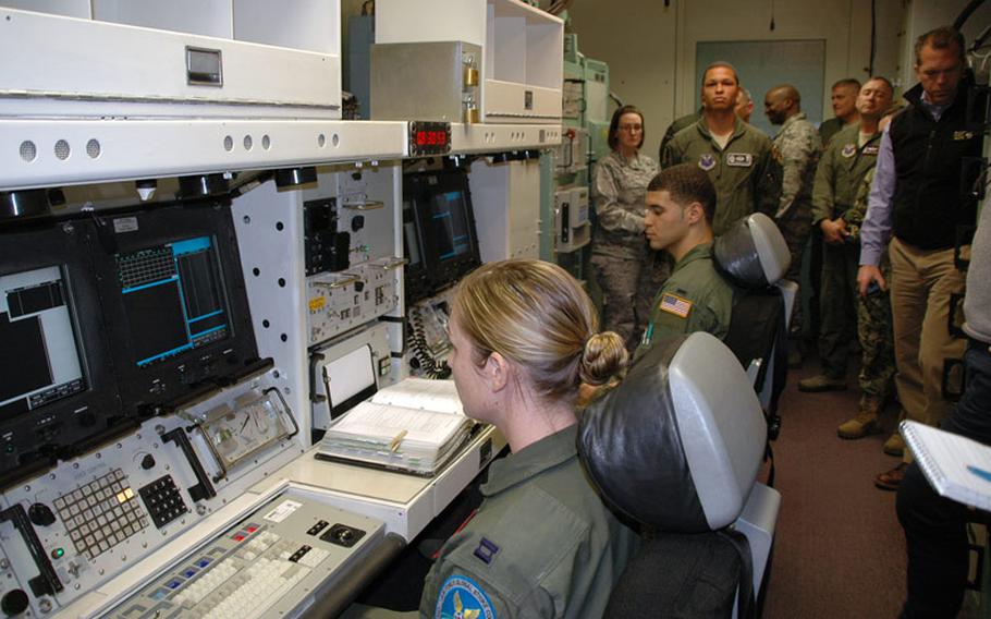 Servicemembers sit inside a nuclear launch control simulator at F.E. Warren Air Force Base used to train missile officers. The simulator is a mockup of a real launch control center.