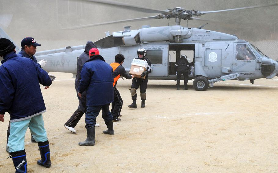 U.S. servicemembers, assigned to a helicopter unit deployed from the USS Ronald Reagan, provide supplies at a coastal Japanese city affected by the devastating March 2011 tsunami caused by a 9.0 magnitude earthquake. 