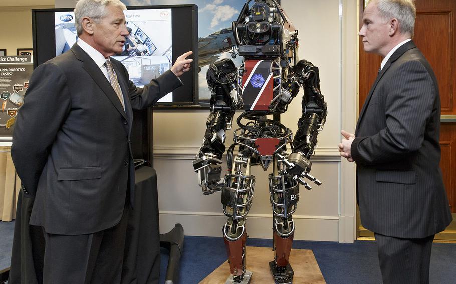 Defense Secretary Chuck Hagel gets a look at the latest high-tech projects being developed for wounded soldiers by the Defense Advanced Research Projects Agency, DARPA, including the ATLAS Robot, center, demonstrated by engineer Brad Tousley, right, Tuesday, April 22, 2014, at the Pentagon. 