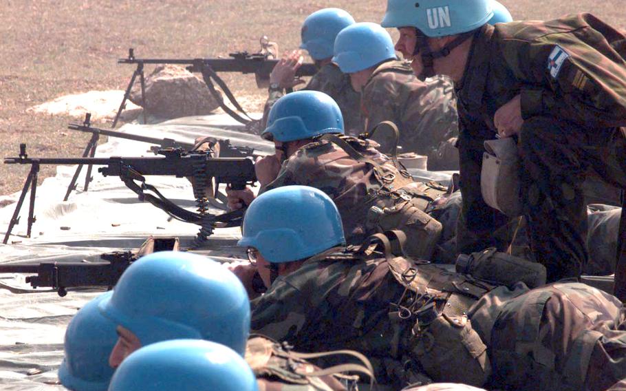 A Finnish officer shouts instructions as Americans test fire Finnish rifles during a live fire exercise Saturday near Skopje airport in Macedonia in March, 1998.  Americans, most of them from Schweinfurt, Germany, make up 350 of the 750 United Nations peacekeepers patrolling Macedonia.  Their patrols border the volatile Kosovo region of Serbia, but the U.S. troops say their mission is to monitor the border, not get involved in potential combat. Their current orders call for them to fire only in self defense. Their blue helmets symbolize the peaceful intent of their military duties.