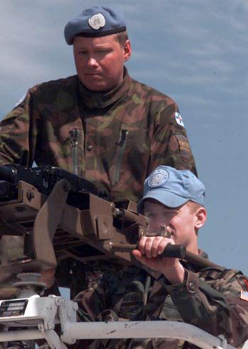 U.S. 2nd Lt. James Cogbill, bottom, tests the sights of a Finnish 12.7mm heavy machine gun as Finnish Capt. Hannu Teittiner gives instructions in Macedonia in March, 1998. Finnish and American troops Saturday practiced using each other's weapons at a range near Skopje airport.