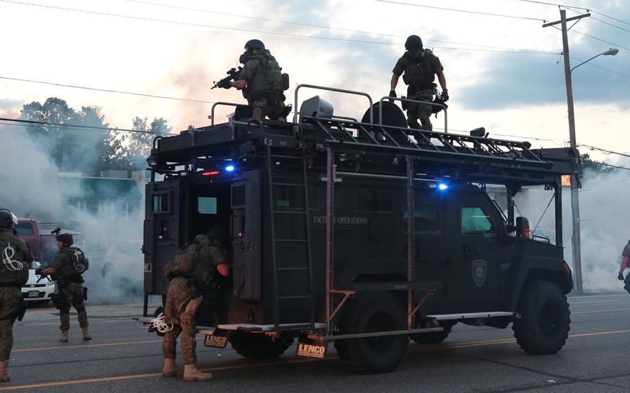 St. Louis County Police tactical officers fire tear gas on West Florissant Road on Monday, August 11, 2014, in Ferguson, Mo.