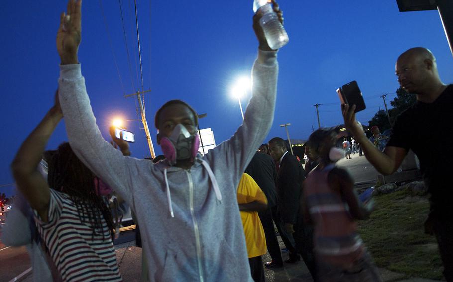 Protesters in Ferguson, Mo., on Tuesday. Protests over the shooting of a black teen by a white police officer have escalated into riots in the St. Louis suburb, and the Missouri governor recently made the controversial decision to call up National Guard troops to assist law enforcement.