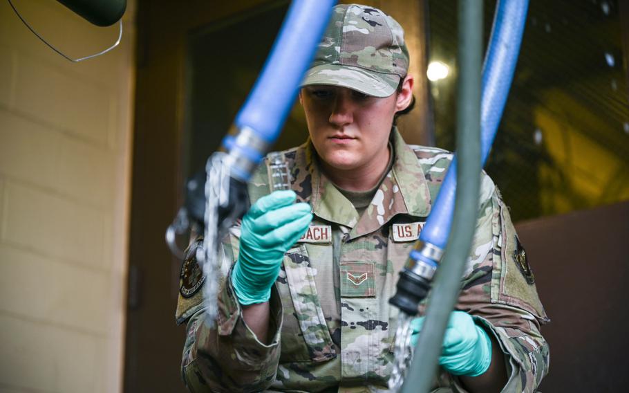 Airman 1st Class Sydni Breitenbach, 15th Operational Medical Readiness Squadron bioenvironmental engineering journeyman, collects a water sample from a Potable Water Module at the Hale Aina Dining Facility at Joint Base Pearl Harbor-Hickam, Hawaii, Dec. 10, 2021.