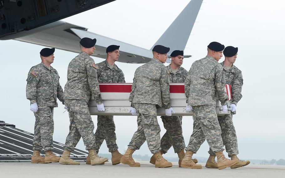 A U.S. Army carry team transfers the remains believed to be Cpl. Justin R. Clouse, of Sprague, Wash., during a dignified transfer June 12, 2014 at Dover Air Force Base, Del. Clouse among five American troops killed in a "friendly fire" incident in southern Afghanistan in June 2014.