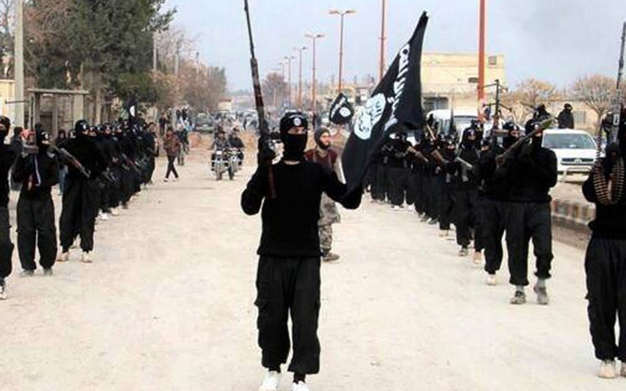In this undated file image posted on a militant website on Tuesday, Jan. 14, 2014, which has been verified and is consistent with other AP reporting, fighters from the Islamic State group march in Raqqa, Syria. 