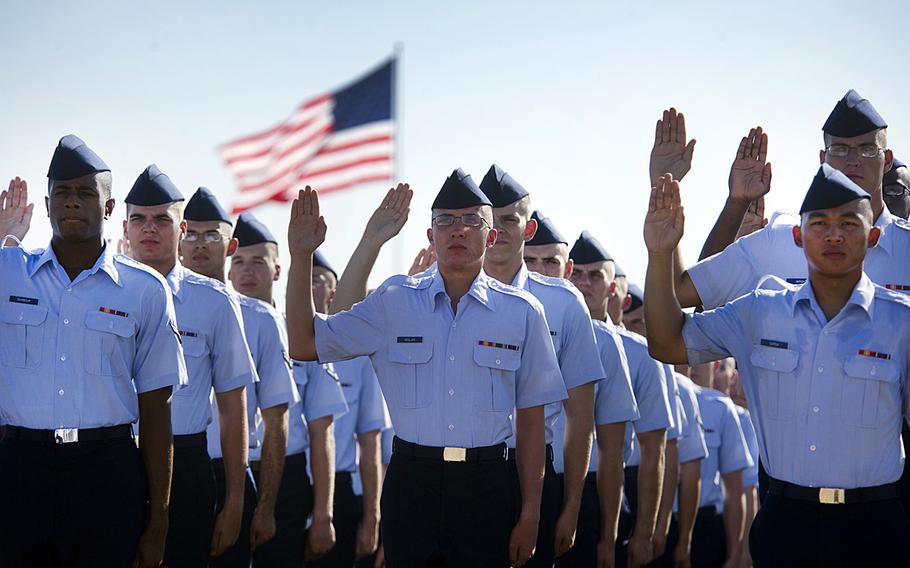 Airmen lift their right hand as they repeat the oath of enlistment at the Air Force Basic Training graduation ceremony, Lackland Air Force Base, Texas, Aug. 19, 2011.