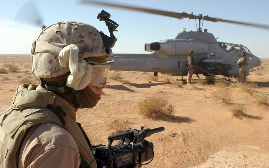 In this 2007 file photo, U.S. Marine Corps Corporal Michael L. Haas, a videographer with 2nd Marine Aircraft Wing, Forward Combat Camera, documents Marines with Marine Heavy Helicopter Squadron 361 refueling an AH-1W Super Cobra from Marine Light/Attack Helicopter Squadron 773 during an aero scout mission over the Al Anbar province, Iraq, on Dec. 8, 2007.