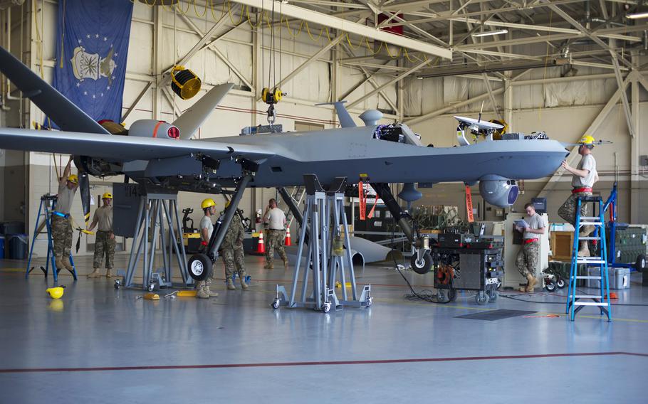 Airmen from Cannon Air Force Base assemble an MQ-9 Reaper at Hurlburt Field, Fla., April 23, 2014.