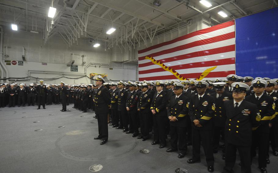 Sailors of the aircraft carrier USS George Washington await the arrival of their new commander aboard the hangar deck Friday. Capt. Greg Fenton handed over command to Capt. Timothy Kuehhas, who will see the ship through a multiyear refueling and overhaul.