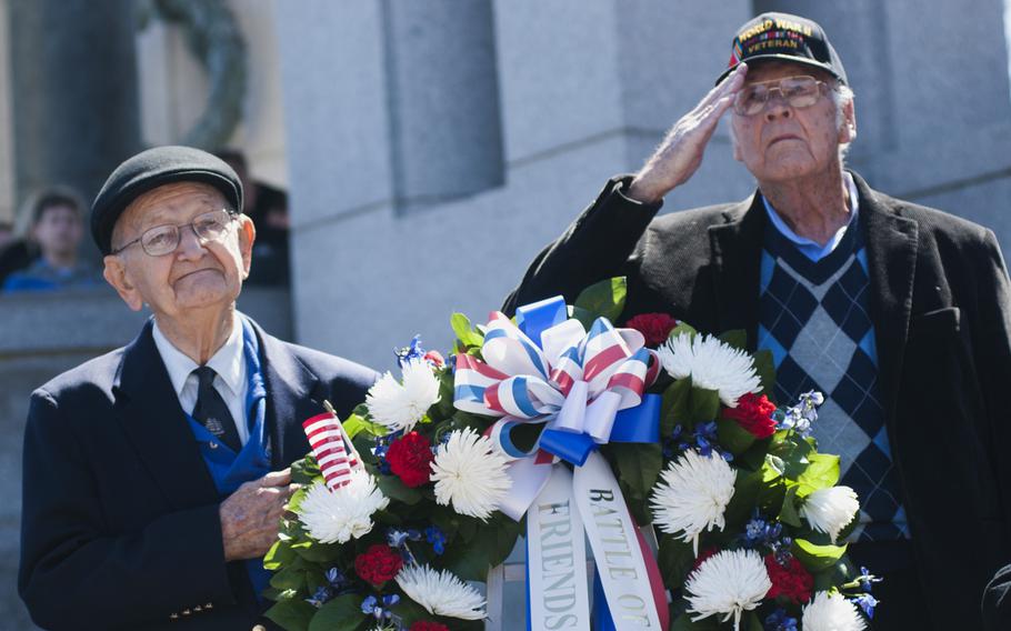 Coast Guard veteran Carroll George (left) and Army veteran Jim Riffe (right), who took part in the Battle of Okinawa, salute during the playing of taps at the WWII Memorial on April 1, 2015. The veterans participated in a wreath-laying to commemorate the 70th anniversary of the battle.