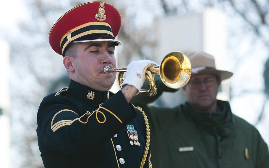 A bugler plays taps at the World War II Memorial during the commemorationg of the 70th anniversary of the Battle of Okinawa on April 1, 2015.