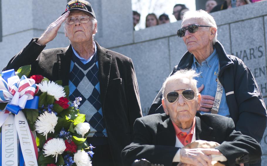 Veterans who fought in the Battle of Okinawa salute during the playing of taps at the World War II Memorial on April 1, 2015. The veterans laid a wreath at the memorial to commemorate the 70th anniversary of the battle. 