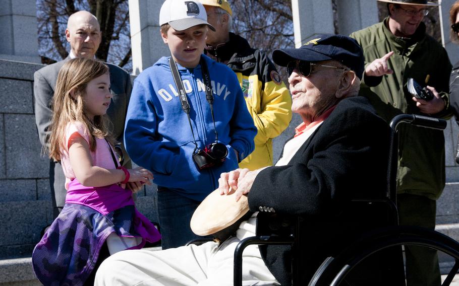 Navy veteran John Cassidy, who fought in the Battle of Okinawa, talks to two youngsters at the World War II Memorial on April 1, 2015. Cassidy participated in a wreath-laying as part of a ceremony commemorating the 70th anniversary of the battle. 