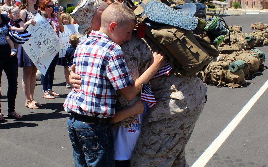 A Marine hugs his children at Camp Pendleton, Calif., on Tuesday, April 14, 2015, as he returned home from a 7 1/2-month deployment to the Middle East with Special Purpose Marine Air Ground Task Force-Crisis Response-Central Command. 