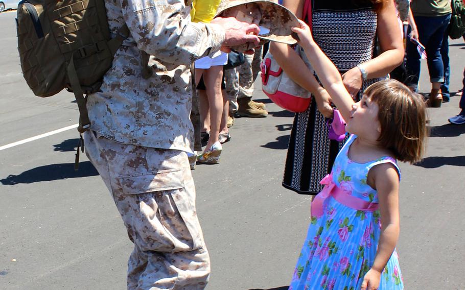 Maggie Jones, 4, returns Capt. Patrick Jones' cover to him Tuesday, April 14, 2015, at Camp Pendleton, Calif. Maggie said she was very excited to have her daddy home after a 7 1/2-month deployment with Special Purpose Marine Air Ground Task Force-Crisis Response-Central Command. 