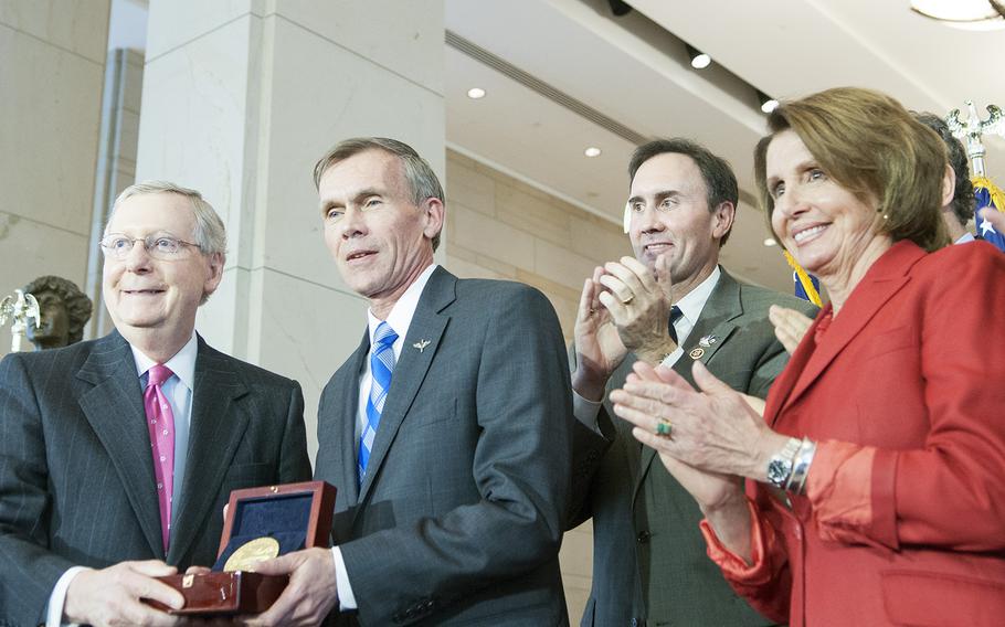 Majority Leader of the Senate Mitch McConnell, R-Ky., presents the Congressional Gold Medal to retired Air Force Lt. Gen. John Hudson, who accepted it on behalf of the Doolittle Tokyo Raiders, who were honored Wednesday, April 15, 2015, during a ceremony on Capitol Hill for their daring bombing raid on mainland Japan on April 18, 1942. Hudson -- director of the National Museum of the Air Force, where the medal will go on display -- is flanked by U.S. Rep. Pete Olson, R-Texas, and Democratic Leader of the House of Representatives Nancy Pelosi, D-Calif.