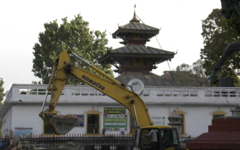 Heavy equipment clears rubble from damaged buildings in Nepal's capital, Kathmandu, on Saturday, May 2, 2015. 