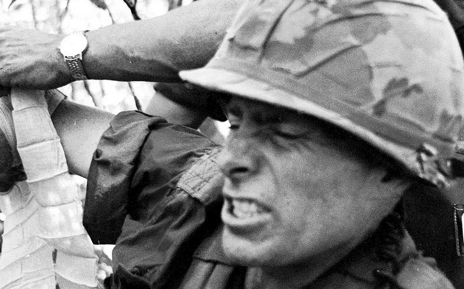 Battalion commander Maj. Guy Meloy III grimaces as his wounded arm is bandaged by a radioman during fighting in an area near Dau Tieng, Vietnam, in November, 1966. Meloy, the son of a general who would himself retire as a major general, was later awarded the Distinguished Service Cross for his actions during the battle.